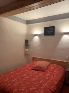 1 dormitorio con 1 cama roja y 2 luces en la pared en Le Jardin de Zé, en Fontaine-de-Vaucluse