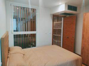 a small bedroom with a bed and a window at Casa Pintáns in Cangas de Morrazo