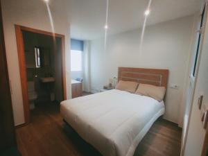 a bedroom with a large bed and a bathroom at Casa Pintáns in Cangas de Morrazo
