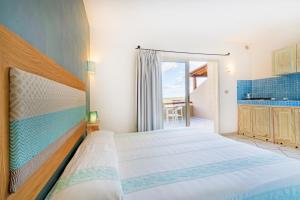 a bedroom with a bed and a view of the ocean at Residence Hotel Lu Nibareddu in San Teodoro