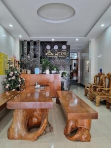 un vestíbulo con mesas de madera y bancos en una tienda en NHÀ NGHỈ T&T en Dồng Văn