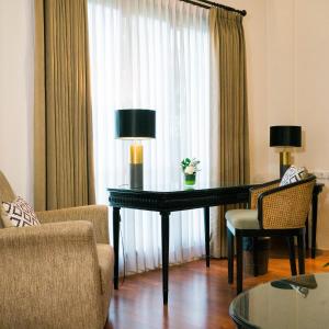 a living room with a table with two lamps and chairs at Umpadhi Canggu in Canggu