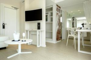 a white living room with a tv and a table at Blanco Hotel Formentera in Es Pujols