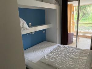 una camera con un letto con una parete blu di VUE MER ET ESTEREL SUR LA BAIE DE CANNES a Théoule-sur-Mer