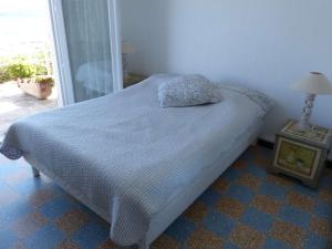 una camera da letto con un letto con un cuscino sopra di Appartement Le Lavandou, 3 pièces, 4 personnes - FR-1-308-25 a Le Lavandou