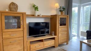 a large wooden entertainment center with a flat screen tv at Nordseebrandung FeWo A4 3 in Sahlenburg