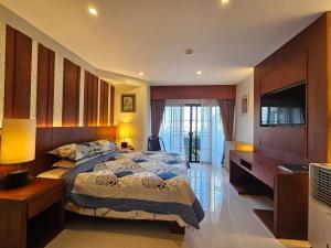 - une chambre avec un lit, un bureau et une télévision dans l'établissement Lakeside Allamanda Apartment, à Bang Tao Beach