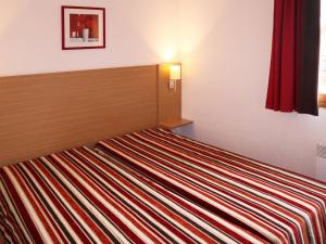 a bedroom with a bed with a striped blanket at Appartement Les Orres, 3 pièces, 8 personnes - FR-1-322-429 in Les Orres