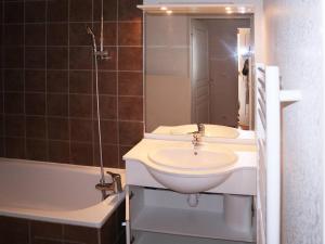ein Badezimmer mit einem Waschbecken, einer Badewanne und einem Spiegel in der Unterkunft Appartement Les Orres, 3 pièces, 8 personnes - FR-1-322-429 in Les Orres
