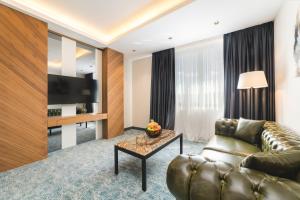 a living room with a couch and a tv at Bristol Hotel Podgorica in Podgorica