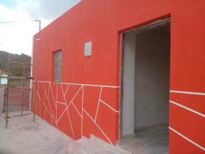 eine rote Wand mit offener Tür an einem Gebäude in der Unterkunft AmarCasa in Nora