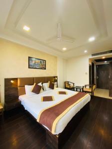 Hotel SS Grandeur في Alambagh: غرفة نوم بسرير كبير في غرفة