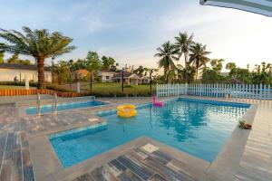 a swimming pool with an inflatable raft in a yard at Misty Barn - "Your Poolside Escape Awaits" in Chikmagalur