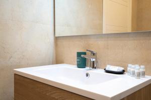 une salle de bain avec un lavabo blanc et un miroir dans l'établissement Central & Elegant Loft - with Balcony, à Bari 9 autres photos