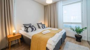 a bedroom with a bed with two towels on it at Rahulihomes Lutakko in Jyväskylä +110 photos