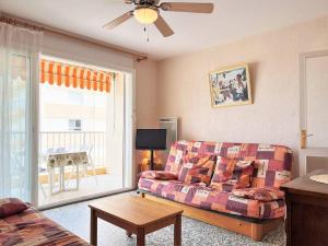 ein Wohnzimmer mit einem Sofa und einem Tisch in der Unterkunft Appartement Le Lavandou, 1 pièce, 4 personnes - FR-1-251-481 in Le Lavandou