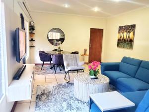 a living room with a blue couch and a table at Mnqobi Lifestyle Apartments in Nelspruit