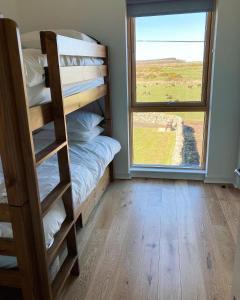 a room with bunk beds and a large window at New Town Hall Bunkhouse in Whithorn