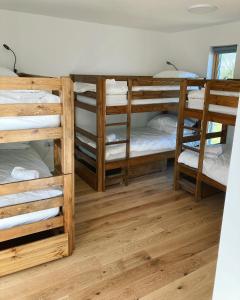 a room with three bunk beds and a wooden floor at New Town Hall Bunkhouse in Whithorn
