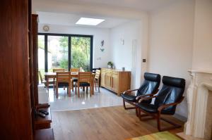 a living room with a dining room table and chairs at 5 bedroom sunlit family house with garden in Redbridge