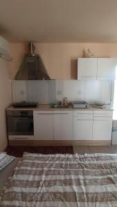 - une cuisine avec des placards blancs et une cuisinière dans l'établissement Kortina 1, à Koper