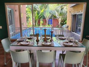 a table with wine bottles and chairs on a balcony at Beach 7 mins walk Luxury villa Diva in Calangute