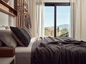 a bedroom with a bed with a large window at Estelle Luxury House in Zakynthos