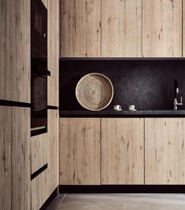 扎金索斯鎮的住宿－Estelle Luxury House，厨房设有木墙和带碗的柜台
