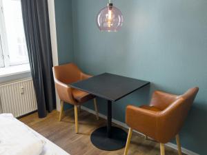 コペンハーゲンにあるwhere to sleepの黒いテーブルと椅子2脚が備わる客室です。