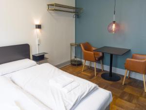 1 dormitorio con 1 cama, mesa y sillas en where to sleep, en Copenhague