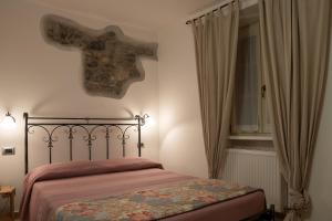 1 dormitorio con cama y ventana en Garnì Centrale, en Roncone