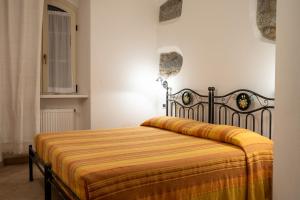 1 dormitorio con 1 cama con manta amarilla en Garnì Centrale, en Roncone