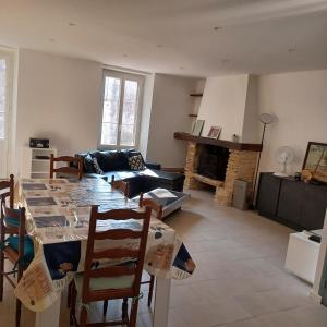 ein Wohnzimmer mit einem Tisch und einem Sofa in der Unterkunft Maison de village entre estuaire et océan in Saint-Yzans-de-Médoc