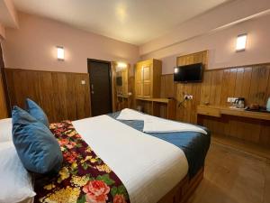 a bedroom with a bed and a tv in a room at Montanamar Lachung in Lachung