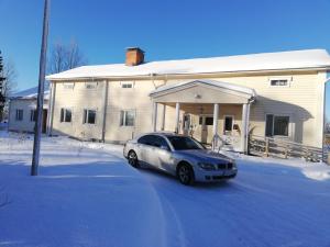 um carro estacionado em frente a uma casa na neve em Kattilakosken vanha Pappila em Kärsämäki