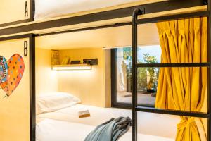 Petit Hostel Palacio Real في مدريد: غرفة نوم بسريرين بطابقين مع ستائر صفراء