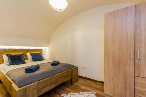 ein Schlafzimmer mit einem Bett mit blauen Kissen darauf in der Unterkunft Charming Central Residence by NeWave Apartments in Budapest