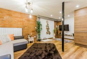 ein Wohnzimmer mit Sofa und Ziegelwand in der Unterkunft Charming Central Residence by NeWave Apartments in Budapest