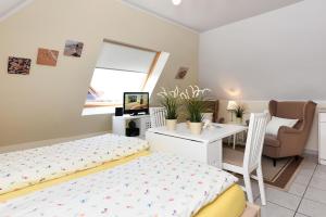 a bedroom with a bed and a desk and a chair at Apartment Typ C im DG, Haus Friedeburg, Carolinensiel in Wittmund
