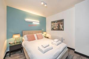 1 dormitorio con 1 cama con toallas en The "Slaycation" Crib - Soho - by Frankie Says en Londres