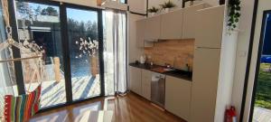 a kitchen with a large window and a kitchen with a sink at Stawy u Sikory - Domek Czapla - Agroturystyka i łowisko in Bledzew