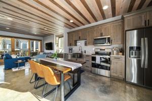 a kitchen with a wooden ceiling and a table and chairs at Rum Away with Me #303 in Chelan