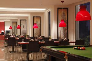 a restaurant with a pool table and red lamps at Red Fox Hotel, Hitech city, Hyderabad in Hyderabad