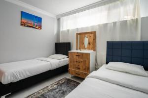 a bedroom with two beds and a dresser and a mirror at Central Istanbul Apartments in Istanbul