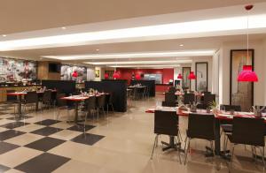 a restaurant with tables and chairs and red lamps at Red Fox Hotel, Hitech city, Hyderabad in Hyderabad