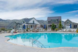 a swimming pool with houses and mountains in the background at Coco Chelan #137 in Chelan