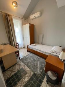 a bedroom with a bed and a desk and a refrigerator at Perla Inn in Osijek