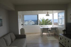 een woonkamer met een bank en een tafel met stoelen bij Mar de Sal in Teguise