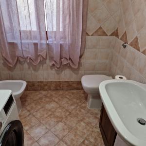 La salle de bains est pourvue de toilettes et d'un lavabo. dans l'établissement Appartamento casa vostra, à Bosa