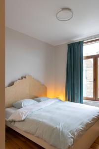 a bedroom with a large white bed with a window at 3 Queens in Bruges